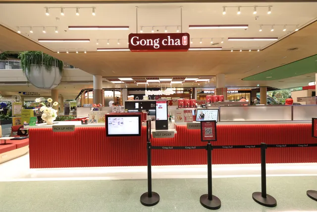 Backlit signage box and striplight ceiling above a retail counter